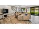 Comfortable living area with a ceiling fan, hardwood floors, large windows, a sectional sofa and staircase at 4083 Woods Rider Loop, Odessa, FL 33556