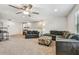 Bright and spacious living room with comfortable seating, ceiling fan, fish tank, and a desk area at 4083 Woods Rider Loop, Odessa, FL 33556