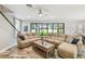 Open-concept living room with a large sectional, hardwood floors, ceiling fan, and sliding glass doors to the backyard at 4083 Woods Rider Loop, Odessa, FL 33556