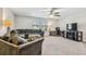 Spacious living room with plush seating, ceiling fan, large windows, desk and carpeted floors at 4083 Woods Rider Loop, Odessa, FL 33556