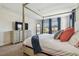 Comfortable bedroom with a canopy bed, TV, dresser, and natural light at 4083 Woods Rider Loop, Odessa, FL 33556