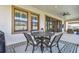 Covered patio featuring a metal table with four chairs and decorative rug, perfect for outdoor dining and relaxation at 4083 Woods Rider Loop, Odessa, FL 33556