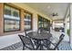Covered patio featuring a metal table with four chairs and decorative rug, perfect for outdoor dining at 4083 Woods Rider Loop, Odessa, FL 33556