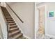 Carpeted staircase with wood railing that leads to a bathroom with tiled floors and a glass-enclosed shower at 4083 Woods Rider Loop, Odessa, FL 33556