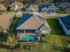 Aerial view of a home with solar panels and a screened-in pool, highlighting its modern amenities and outdoor living space at 4197 Glade Wood Loop, New Port Richey, FL 34655
