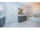 Stylish bathroom featuring double vanity, stand alone tub and luxurious marble floors and wallpaper at 4197 Glade Wood Loop, New Port Richey, FL 34655