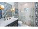 Elegant bathroom with a glass shower, marble tiling, patterned wallpaper, and modern fixtures at 4197 Glade Wood Loop, New Port Richey, FL 34655