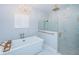 Bathroom featuring a stand alone tub, chandelier, stylish wallpaper, and shower with glass door at 4197 Glade Wood Loop, New Port Richey, FL 34655