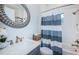 Charming bathroom with a decorative mirror, stylish vanity, and a bathtub with a blue and white curtain at 4197 Glade Wood Loop, New Port Richey, FL 34655