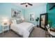 Inviting bedroom with soft blue walls, plush bedding, stylish decor, and a large window with shutters at 4197 Glade Wood Loop, New Port Richey, FL 34655