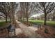 Peaceful community park with benches along a sidewalk lined with trees and greenery at 4197 Glade Wood Loop, New Port Richey, FL 34655