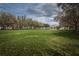 Expansive green space with lush lawn, mature trees, and a charming gazebo in the distance at 4197 Glade Wood Loop, New Port Richey, FL 34655