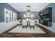 An elegant dining room with hardwood floors, wainscoting, shuttered windows, and modern lighting at 4197 Glade Wood Loop, New Port Richey, FL 34655