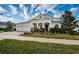 Charming single-story home featuring a manicured lawn, paver driveway, and an attached two-car garage at 4197 Glade Wood Loop, New Port Richey, FL 34655