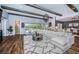 Spacious living room featuring hardwood floors, a large sectional sofa, wood beams, and backyard views at 4197 Glade Wood Loop, New Port Richey, FL 34655