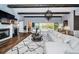 Spacious living room with stone fireplace, wood beams, and view of the pool at 4197 Glade Wood Loop, New Port Richey, FL 34655
