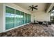 Covered patio with brick floors, ceiling fan, and comfortable seating area offers great space for relaxing and enjoying the outdoors at 4197 Glade Wood Loop, New Port Richey, FL 34655