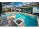 Stunning screened-in pool and spa with rock detail and lush landscaping creates a serene outdoor retreat for relaxation and entertainment at 4197 Glade Wood Loop, New Port Richey, FL 34655