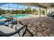 Beautiful screened-in pool with lounge chairs, brick pavers, and a spa offer a relaxing oasis and picturesque setting at 4197 Glade Wood Loop, New Port Richey, FL 34655