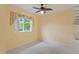 Bedroom features a ceiling fan, carpeted floors, neutral walls, and a window with patterned curtains at 4351 Mallard Lake Dr, Spring Hill, FL 34609
