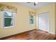 Bright bedroom features two windows, floral valances, hardwood floors, and a closet at 4351 Mallard Lake Dr, Spring Hill, FL 34609