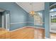 Elegant dining room with hardwood floors, chandelier, and a window letting in plenty of natural light at 4351 Mallard Lake Dr, Spring Hill, FL 34609