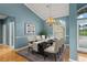 Formal dining room featuring a chandelier, and a view of the property's lush landscaping at 4351 Mallard Lake Dr, Spring Hill, FL 34609