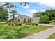 Stunning single-story home with manicured lawn, lush landscaping, and a beautiful palm tree at 4351 Mallard Lake Dr, Spring Hill, FL 34609