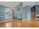Elegant living room featuring hardwood floors, chandelier, and light blue walls at 4351 Mallard Lake Dr, Spring Hill, FL 34609