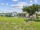 This backyard has lush lawn with a screen room on the house and mature landscaping at 4567 Great Lakes S Dr, Clearwater, FL 33762