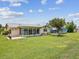 The home's backyard features a large lawn, a screen room, and a patio perfect for entertaining at 4567 Great Lakes S Dr, Clearwater, FL 33762
