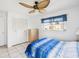 Bright bedroom with a ceiling fan, closet, dresser, window, and bed with a blue comforter at 4567 Great Lakes S Dr, Clearwater, FL 33762