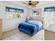 This is a bedroom featuring a ceiling fan, window, and bed with a blue comforter at 4567 Great Lakes S Dr, Clearwater, FL 33762