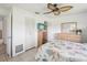Bright bedroom with a ceiling fan, closet, dresser, TV, and bed with a coastal-themed comforter at 4567 Great Lakes S Dr, Clearwater, FL 33762