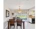 Bright dining area with a decorative mirror, chandelier, and sliding glass doors to the backyard at 4567 Great Lakes S Dr, Clearwater, FL 33762