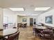A spacious community game room features wood-look floors, tables, chairs, natural light, and neutral decor at 4567 Great Lakes S Dr, Clearwater, FL 33762