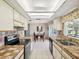 Bright kitchen with white cabinets, tile countertops, stainless steel appliances and a view into the dining room at 4567 Great Lakes S Dr, Clearwater, FL 33762