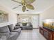 Open living room with tile floors, a ceiling fan, a couch, and a view of the entry door at 4567 Great Lakes S Dr, Clearwater, FL 33762