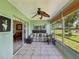 An inviting sunroom features tile floors, a ceiling fan, and a sliding door to the adjacent dining area at 4567 Great Lakes S Dr, Clearwater, FL 33762