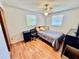 Bright bedroom featuring wood floors, a ceiling fan, and two windows offering natural light at 4628 Irene Loop, New Port Richey, FL 34652
