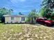 A cozy single-story home with a well-maintained lawn and a red SUV parked in the driveway at 4628 Irene Loop, New Port Richey, FL 34652