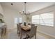 Bright dining room featuring a wooden table, gray chairs, a modern chandelier, and access to the outside at 4752 Weasel Dr, New Port Richey, FL 34653