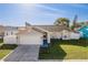 Well-maintained single-Gathering home with a green lawn and a two-car garage at 4752 Weasel Dr, New Port Richey, FL 34653