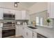 Modern kitchen featuring white cabinets, stainless appliances, white countertops, and a stylish backsplash at 4752 Weasel Dr, New Port Richey, FL 34653