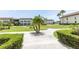 Lush green lawns, mature palm trees, and a winding walkway offer a serene community setting at 4754 Marine Pkwy # 103, New Port Richey, FL 34652