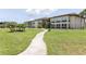 Inviting condo complex exterior featuring lush landscaping and a serene walkway on a sunny day at 4754 Marine Pkwy # 103, New Port Richey, FL 34652