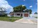 Adorable single story home with white picket fence, mature shade trees, and an inviting exterior at 4853 Alcea St, New Port Richey, FL 34652