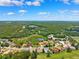 Expansive aerial view features homes surrounded by lush greenery and a pond at 5121 Delacroix Dr, Brooksville, FL 34604