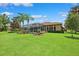 Spacious backyard with a screened-in pool and lush green grass, perfect for outdoor activities at 5121 Delacroix Dr, Brooksville, FL 34604