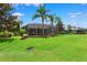 Expansive backyard with mature trees, a screened-in pool enclosure, and lush greenery at 5121 Delacroix Dr, Brooksville, FL 34604